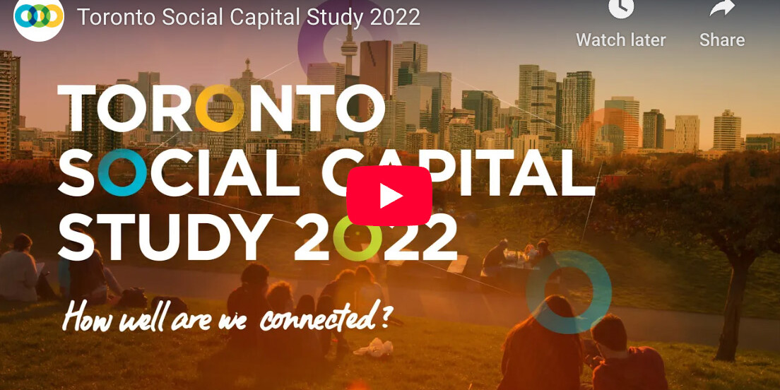 Screenshot of the Toronto Social Capital Study 2022 video, featuring people sitting on grass in a park with the Toronto skyline behind them and text overlaying the image.