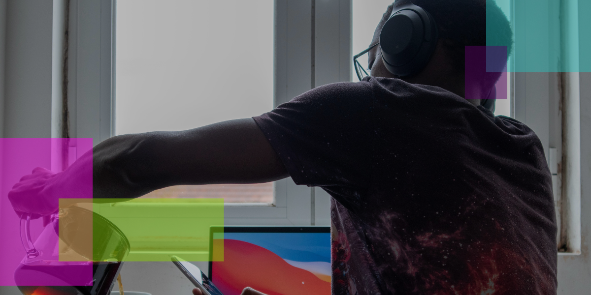Illustrating the shift to remote work, a person wearing headphones pours a drink while using a tablet at a desk in front of a window. An open laptop and colorful translucent rectangles complete the modern work-from-home scene.