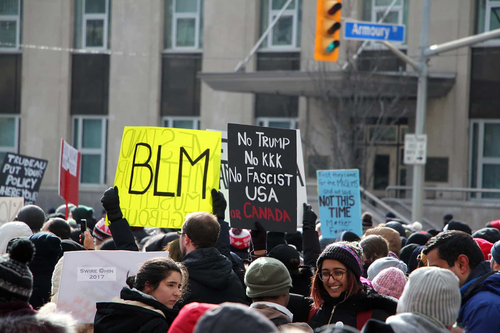 A diverse crowd of protesters holds signs like “BLM” and “No Trump, No KKK, No Fascist USA or Canada,” as Canadians are waking up to the reality of racism. Now is the time for leaders to act on city streets under traffic lights and street signs.